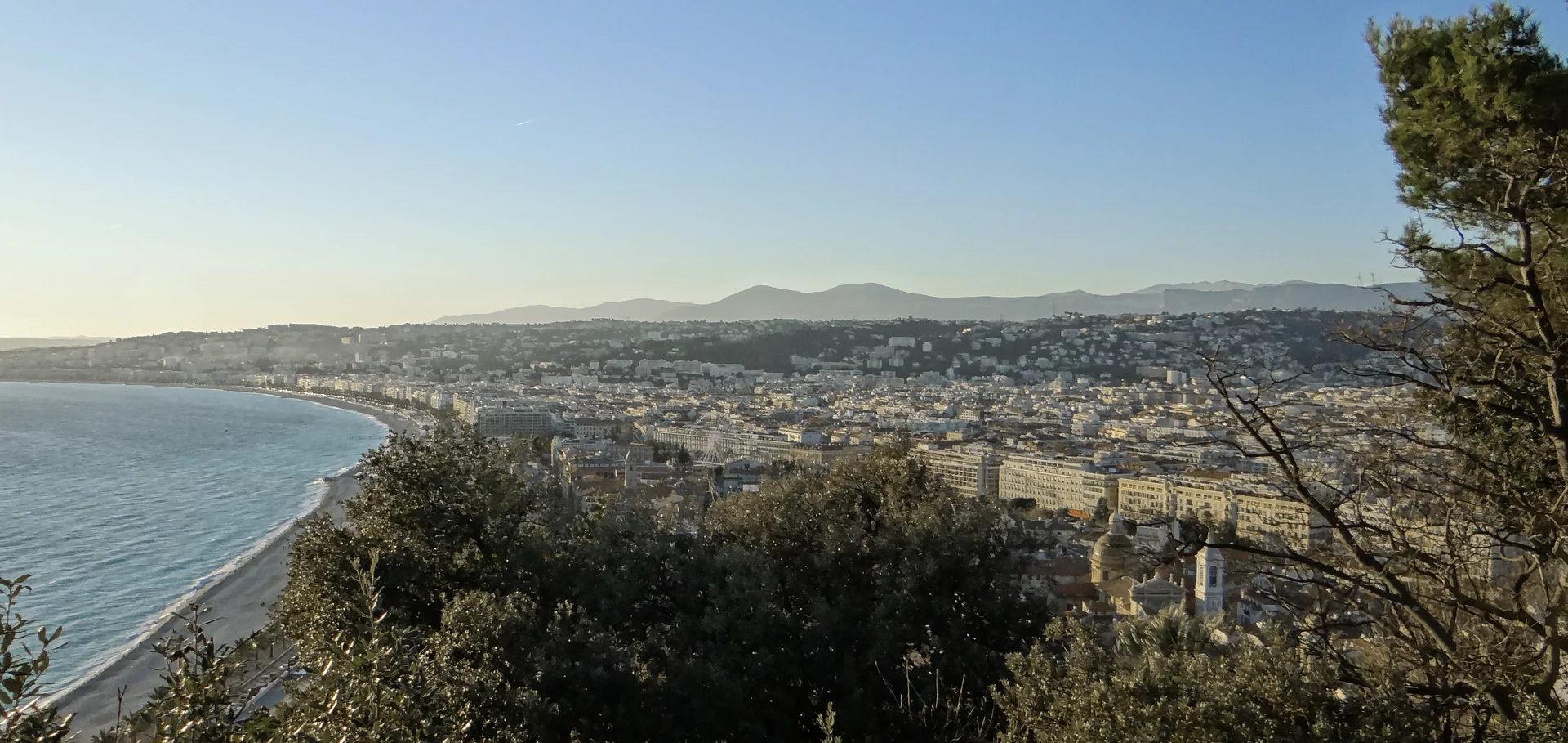 Panorama documental de Nice que reúna cidade construída, frente marítima e relevo, sem apresentar praia ou serviço turístico como produto.